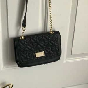 Black cross body bag with a bow on the strap